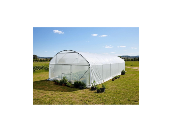 White greenhouse on a grassy field with a clear blue sky